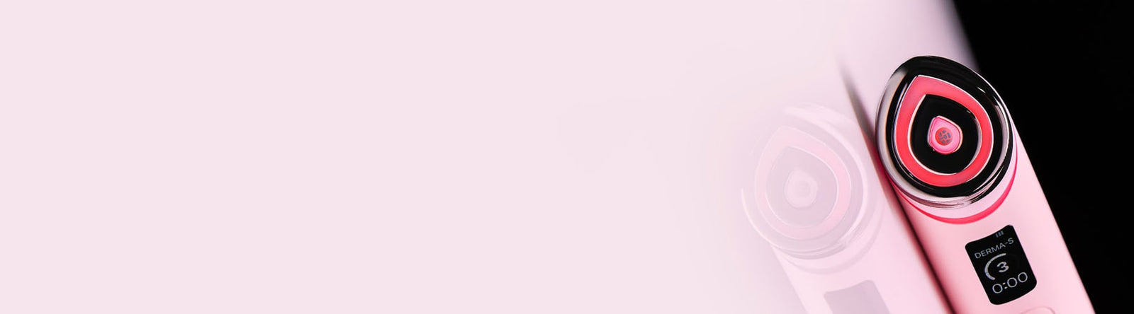Gros plan d'un appareil électronique de soin rose avec une tête circulaire éclairée en rouge à droite, se reflétant sur une surface brillante. L'écran numérique affiche une minuterie de 3 minutes. Fond rose pâle.