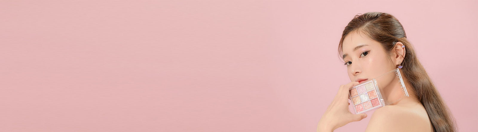 Jeune femme coréenne maquillée montrant une palette de fards à paupière