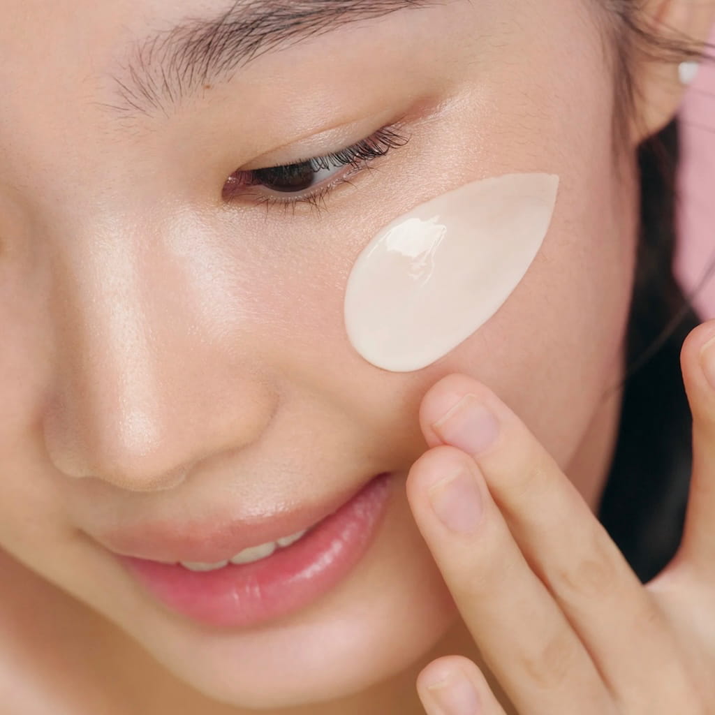 Application de la crème de nuit fermeté Beauty of Joseon au ginseng et rétinal sur le visage.