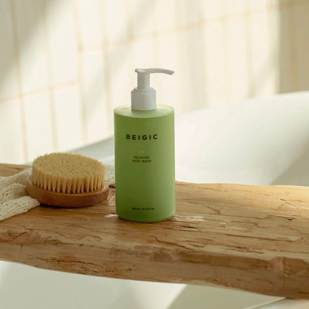 Flacon pompe minimaliste et transparent de 300ml du Relaxing Body Wash de BEIGIC, un gel douche vegan premium couleur ambrée.