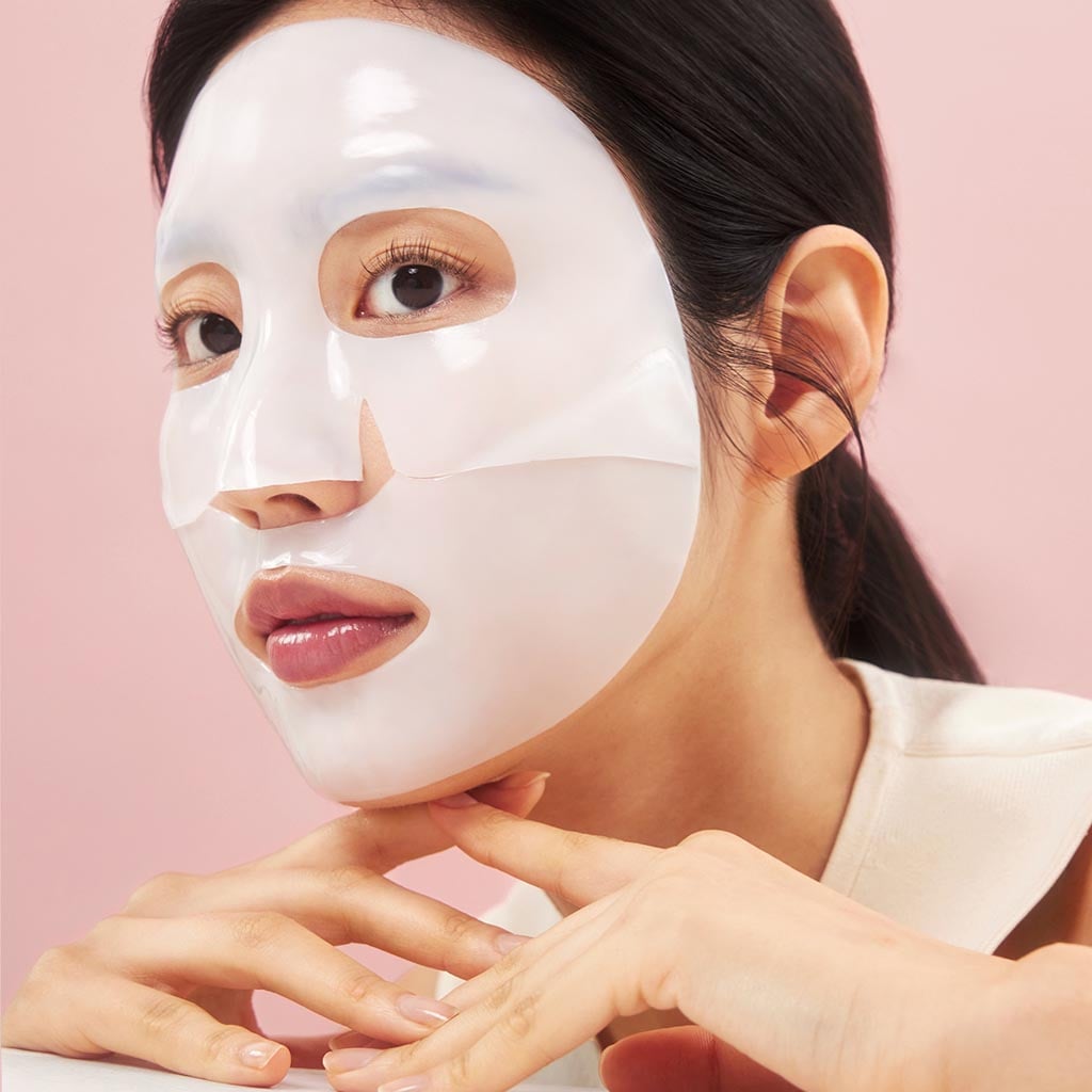 Jeune femme coréenne avec surr le visage BIODANCE Bio Collagen Real Deep Mask, masque hydratant, réduisant les pores, et raffermissant la peau du visage, véritable soin du visage anti-âge