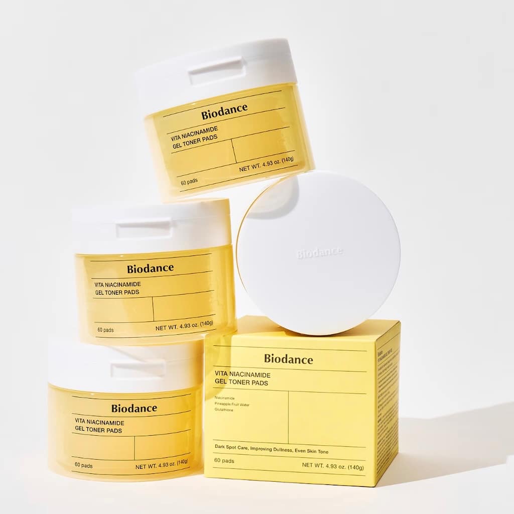 Application des disques toniques hydrogel BIODANCE Vita Niacinamide sur les joues pour illuminer le teint.