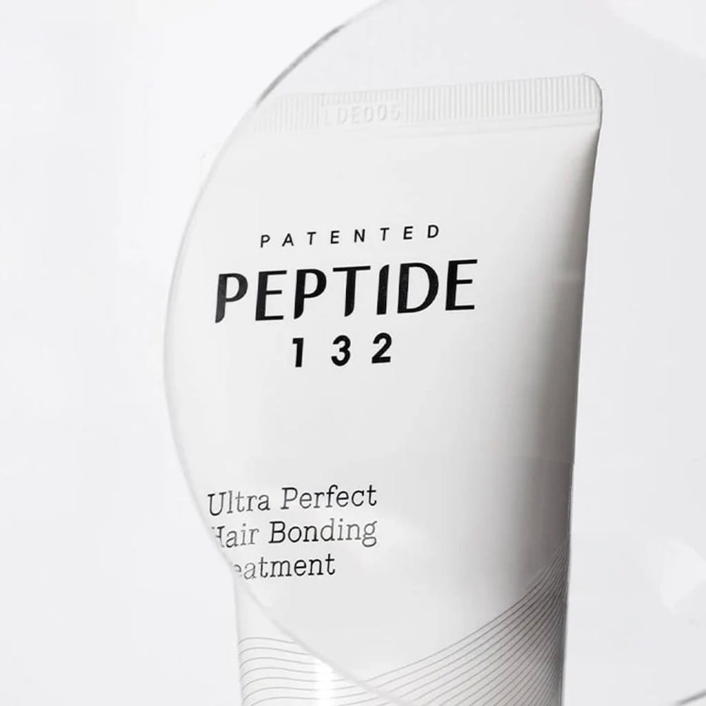 Application du traitement capillaire COSRX PEPTIDE-132 sur les longueurs pour démêler et réparer.