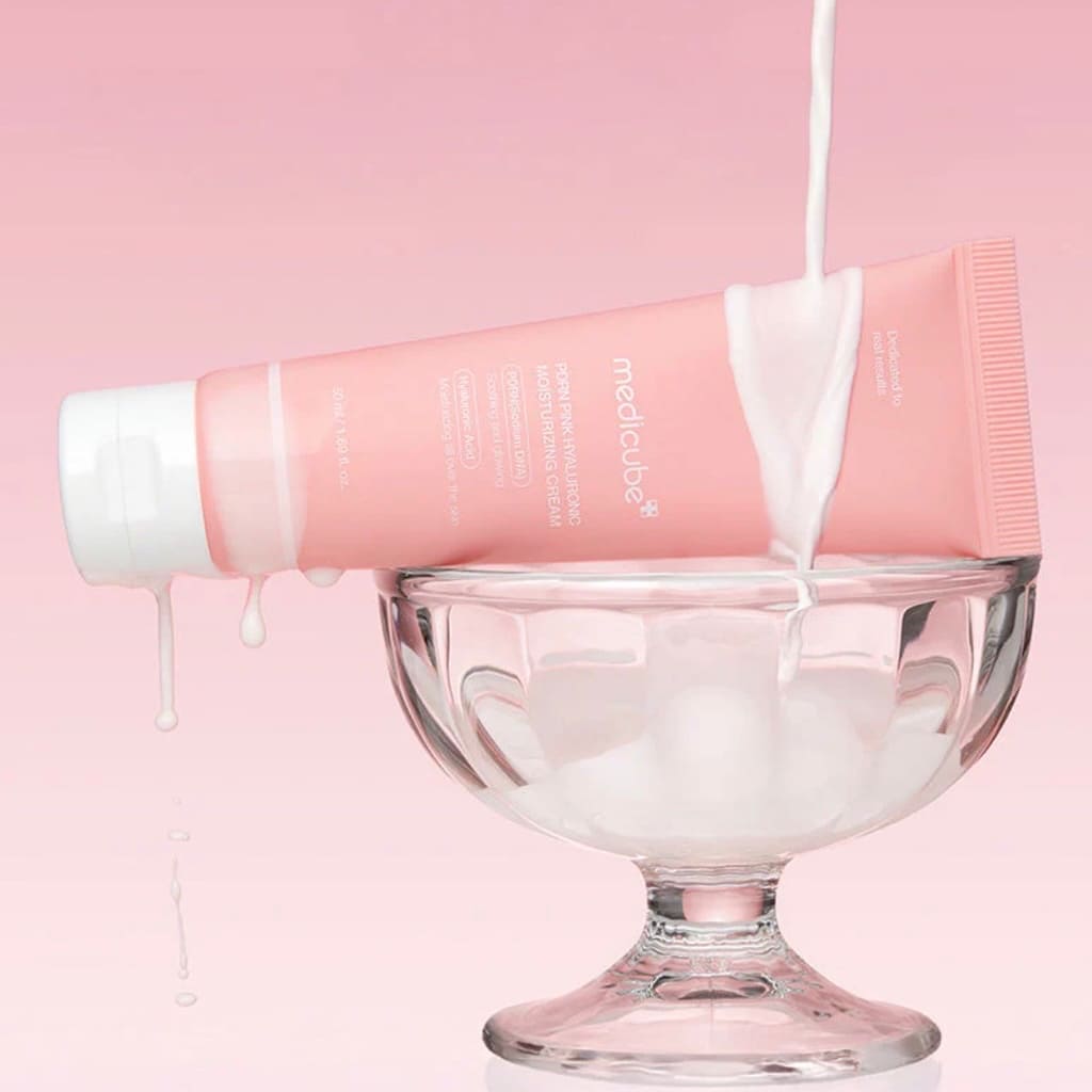 Application de la crème hydratante PDRN Pink Medicube sur la peau pour raviver l'éclat du teint.