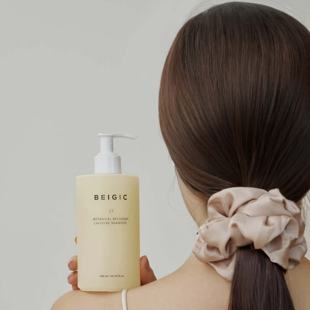 Flacone con pompa minimalista e traslucido da 300ml del Botanical Recovery Caffeine Shampoo di BEIGIC, un trattamento premium anticaduta per capelli.