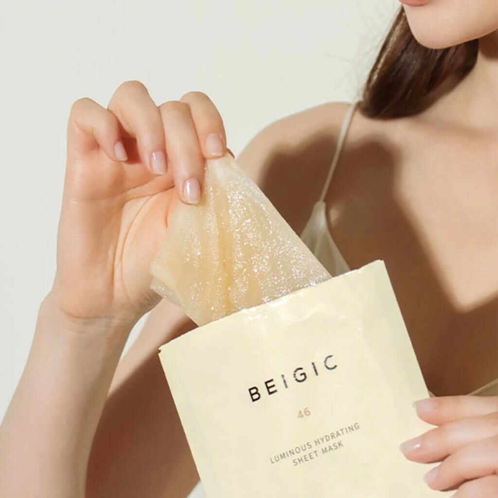 Gros plan sur le tissu en fibres de bambou du masque BEIGIC, généreusement imbibé d'une texture sérum blanche, fluide et intensément hydratante.