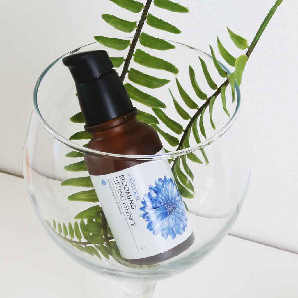 Blooming Lifting Essence de la marque cosmétique coréenne ALL NATURAL, Essence régénérant visage à la fleur de bleuet, soin boostant anti-âge pour votre peau, la renforçant contre le stress oxydatif, stimulant son renouvellement cellulaire, l'hydratant en profondeur, et illuminant son teint.